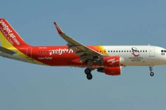 Thai VietJet Air plane mid-flight against clear blue sky, promoting 0 Baht fares between Thailand and Kolkata