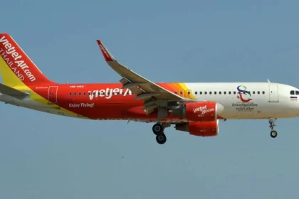 Thai VietJet Air plane mid-flight against clear blue sky, promoting 0 Baht fares between Thailand and Kolkata