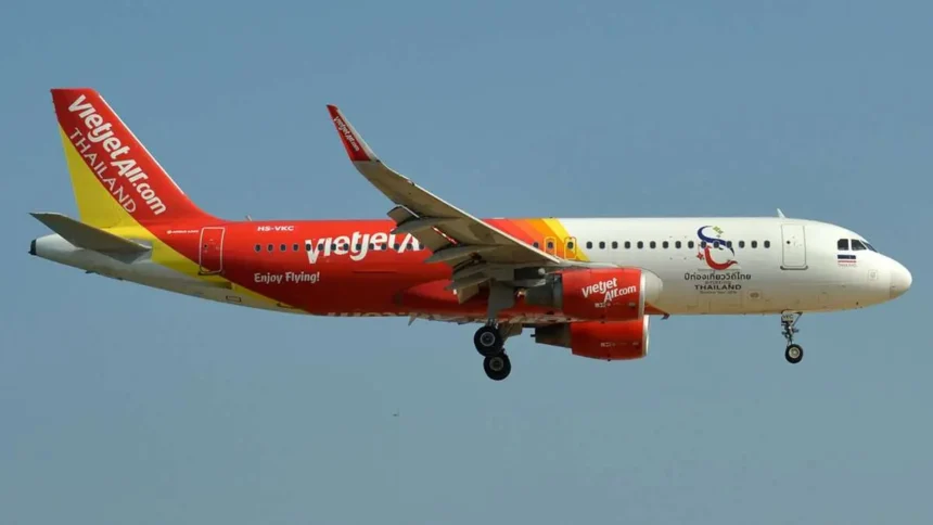 Thai VietJet Air plane mid-flight against clear blue sky, promoting 0 Baht fares between Thailand and Kolkata